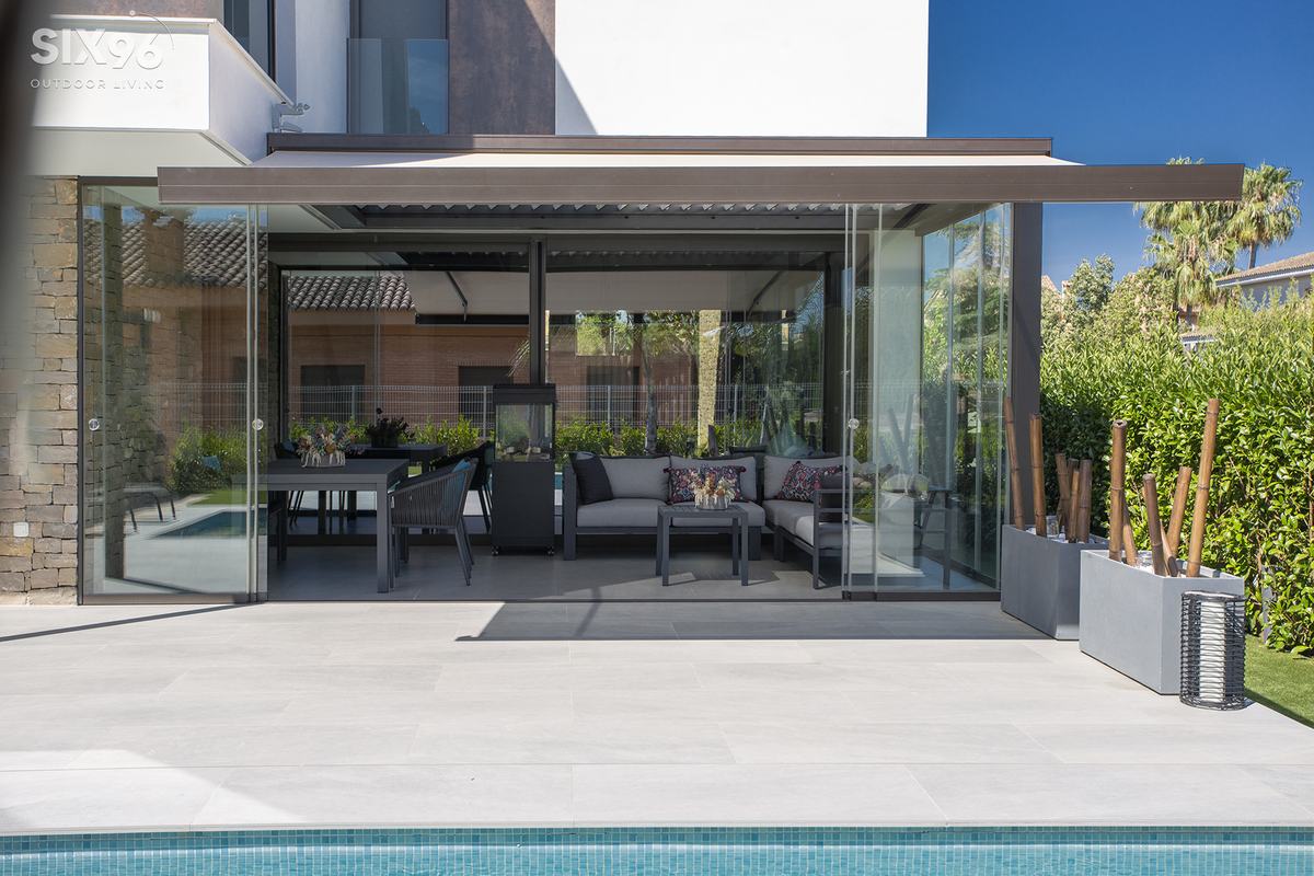 Pergola mit Glasschiebewänden an einem Haus mit Pool