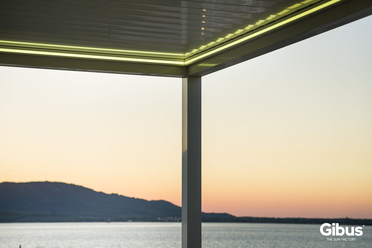 Pergola bei Sonnenuntergang über dem Wasser mit Lichtlinie
