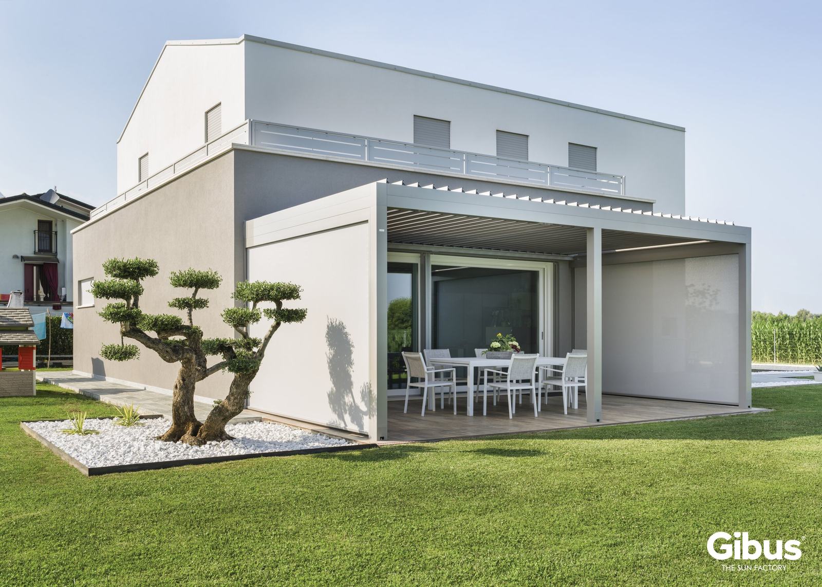 Weiße Pergola an einem modernen Einfamilienhaus mit Rasen